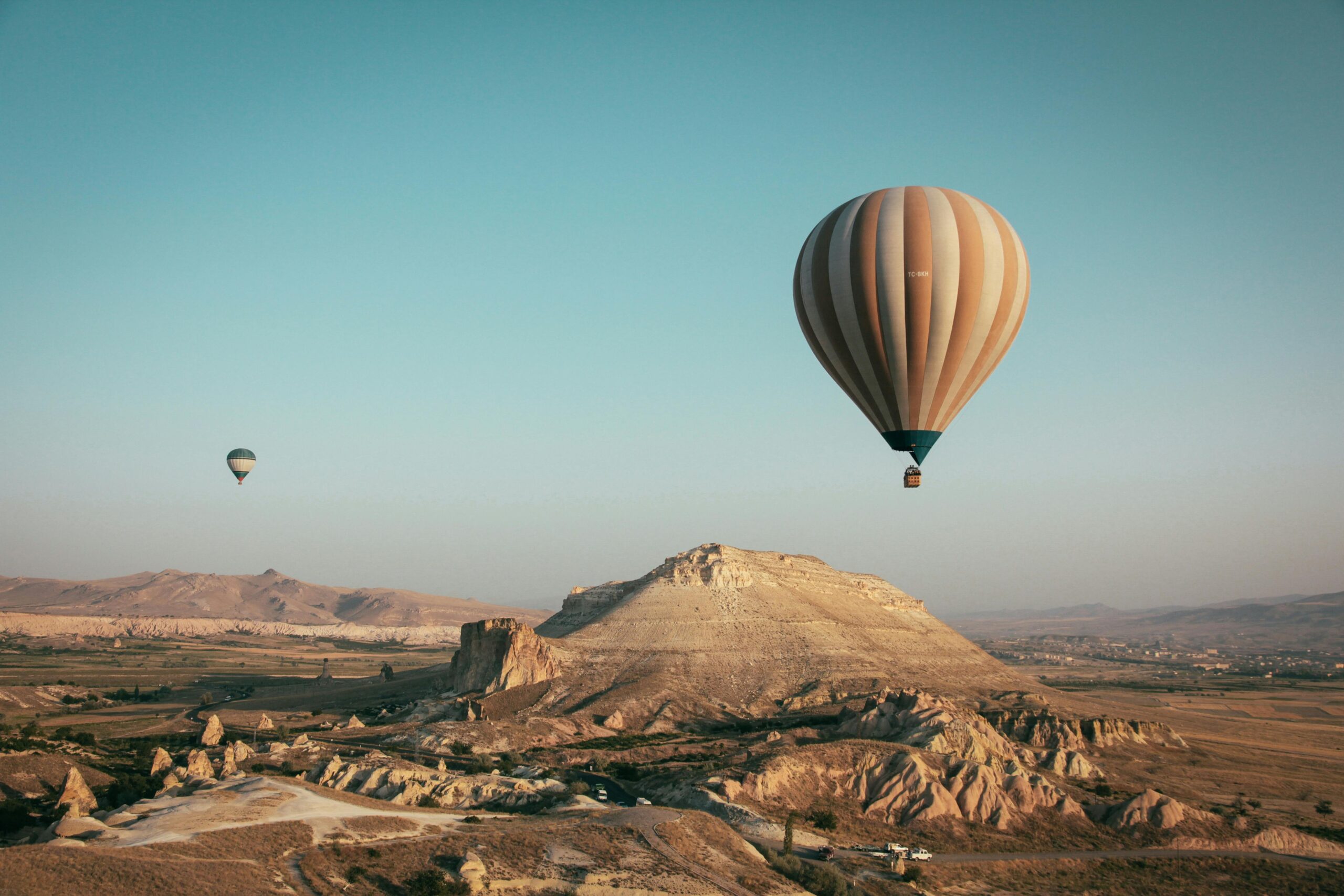 Heißluftballons schweben über einer hügeligen Landschaft Pareto Planer