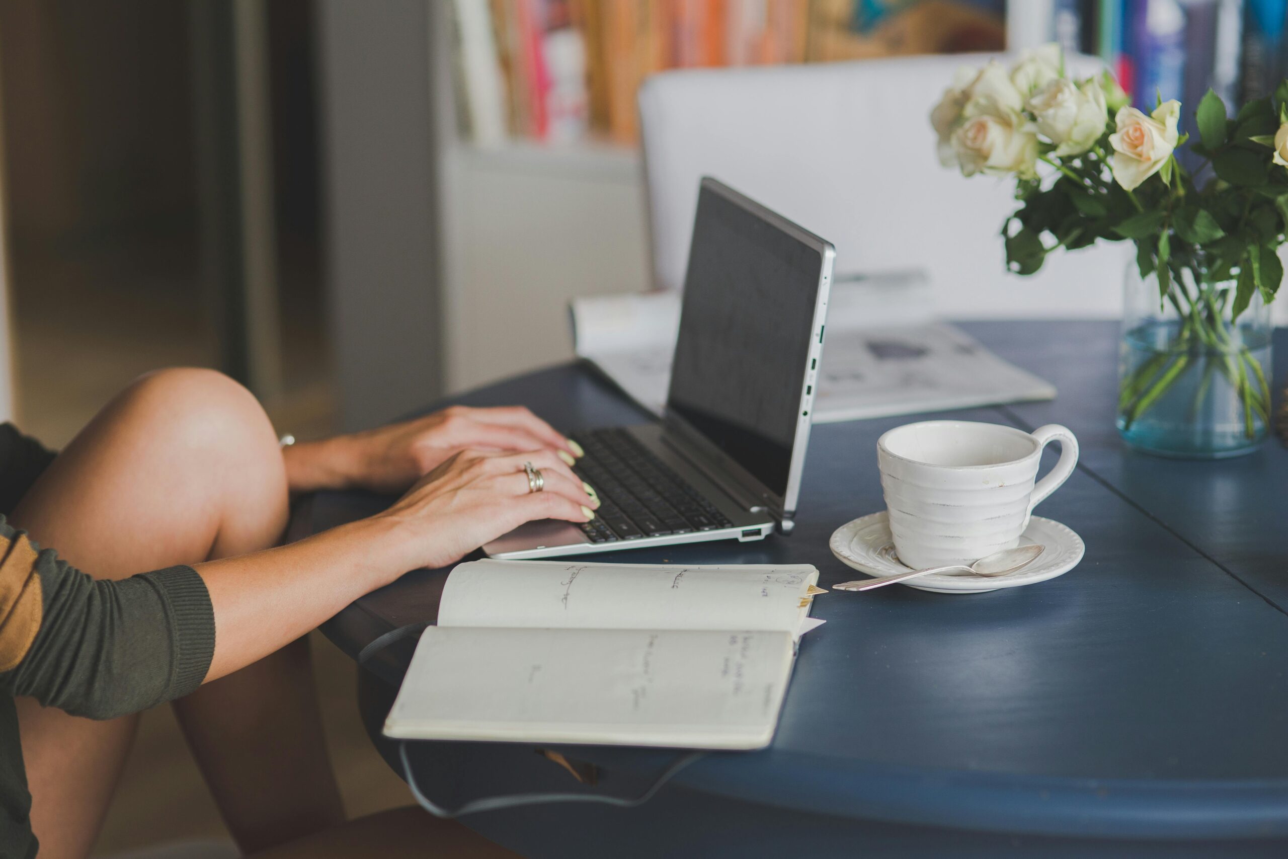 Einsamkeit im Homeoffice, eine ein Tisch mit einem Laptop an dem eine Frau arbeitet