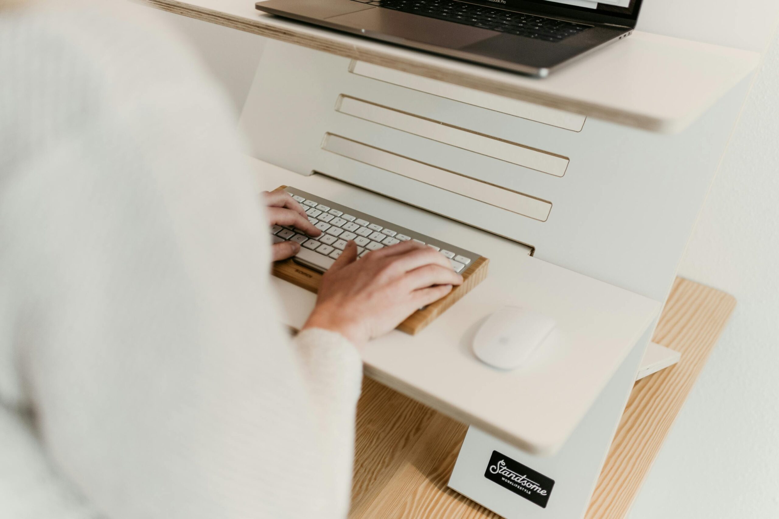 eine Frau arbeitet an einem Steharbeitsplatz zum Thema Anti-Ermüdungsmatte fürs Büro